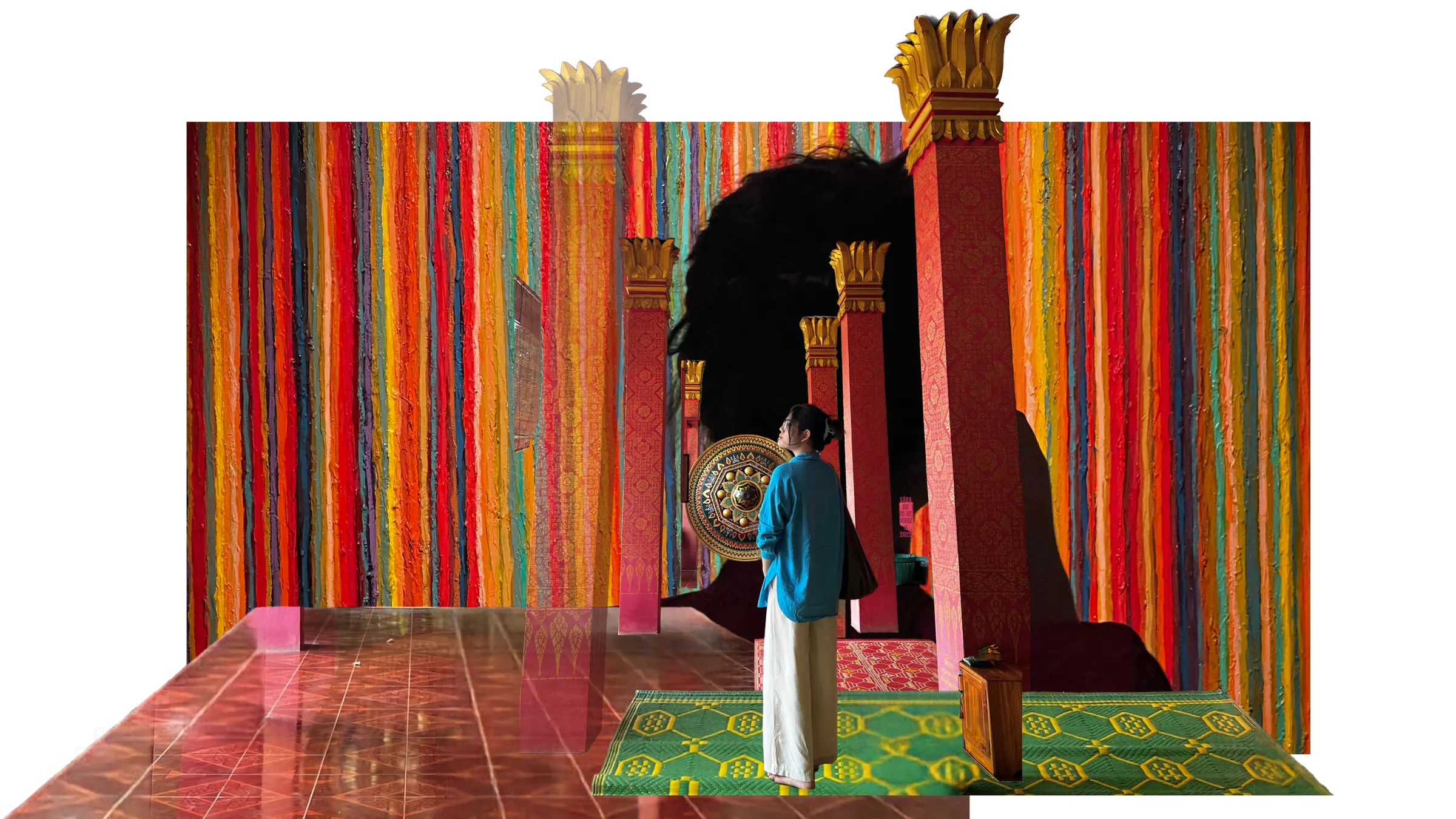 A collage on white: Cam Anh in a blue shirt stands between red temple pillars with gold tops, in front of a wall of thick vertical stripes of colourful paint, on a green woven mat.