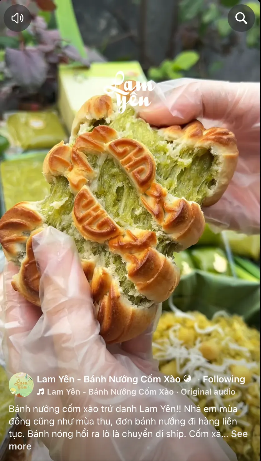 A video still: a gloved hand holds a baked mooncake with green filling showing, green gift boxes and a basket behind it.